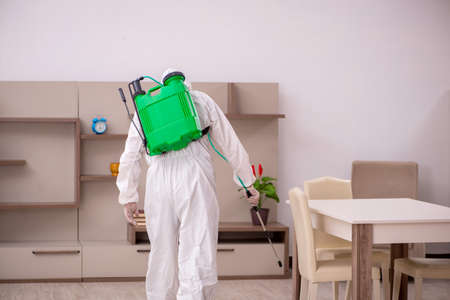 Young male contractor doing pest control at homeの写真素材