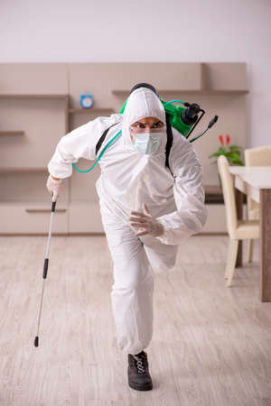 Young male contractor doing pest control at homeの写真素材