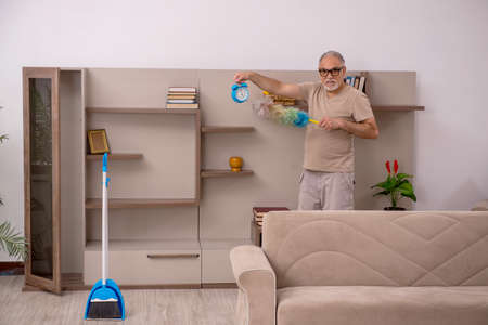 Old man doing housework at homeの写真素材