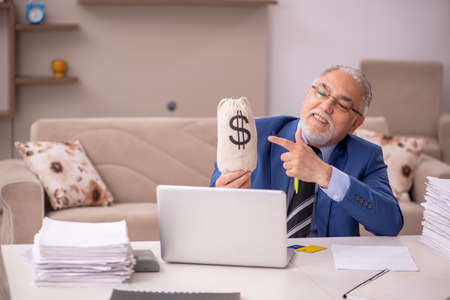 Old male boss working from home in remuneration conceptの写真素材