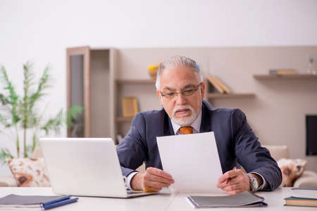 Old male employee working from home during pandemic