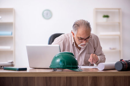 Old male architect working in the officeの写真素材