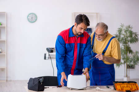 Two male repairmen working at workshop