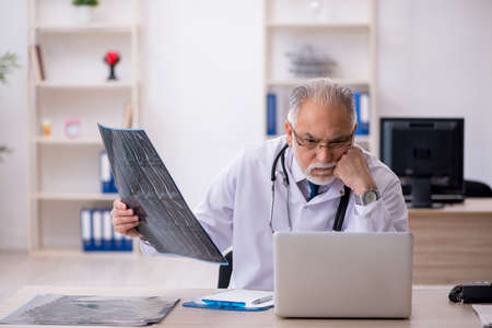 Old male doctor radiologist working in the clinicの写真素材