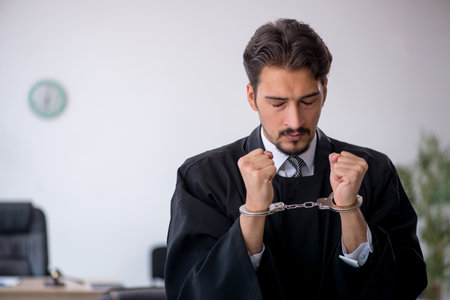 Young male judge in corruption conceptの写真素材