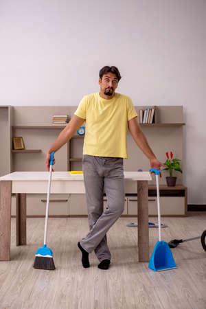 Young man doing housework at homeの写真素材