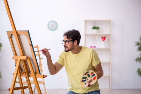 Young man enjoying painting at homeの写真素材