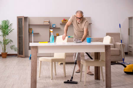 Old man doing housework at homeの写真素材