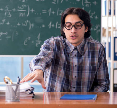 The young funny math teacher in front of chalkboardの写真素材