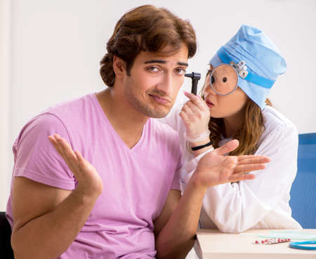 The young handsome man visiting young female doctor otolaryngolo