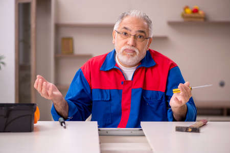 Old male carpenter working indoorsの写真素材