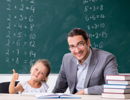 Teacher with young girl in the classroomの写真素材