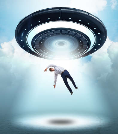 Flying saucer abducting young businessmanの写真素材