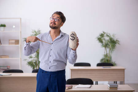 Young male teacher in remuneration conceptの写真素材