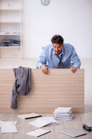 Young male employee working overtime in the officeの写真素材