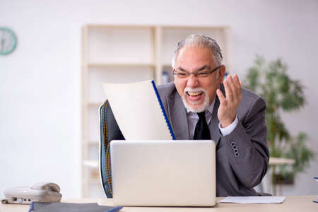 Old male employee working in the officeの写真素材