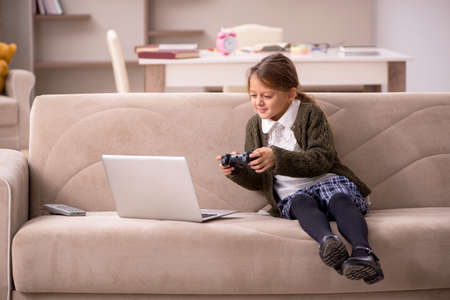 Young little girl playing joystick games at home