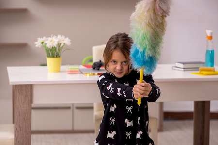Young little girl doing housework at homeの写真素材