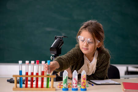 Young little girl chemist in drugs synthesis concept