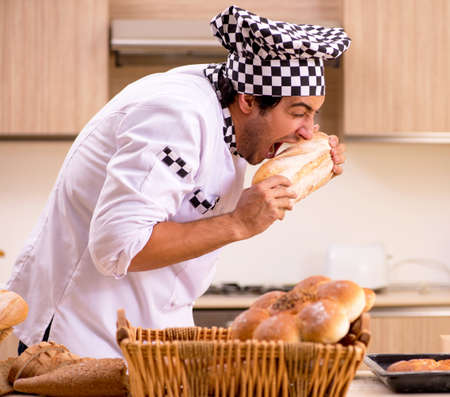 Young male baker working in kitchenの写真素材