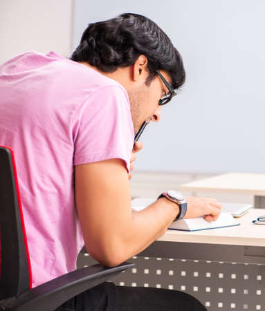 The young male student sitting in the classの写真素材