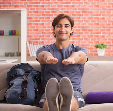 Young handsome man doing sport exercises at homeの写真素材