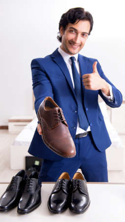 Young handsome businessman choosing shoes at homeの写真素材