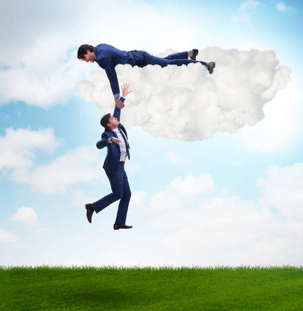 Businessman offering helping hand to falling colleagueの写真素材