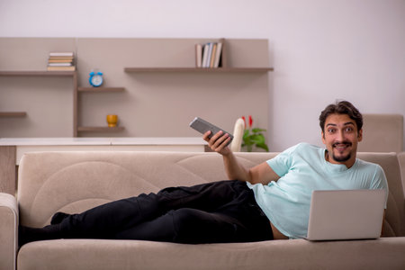Young man watching tv at homeの写真素材