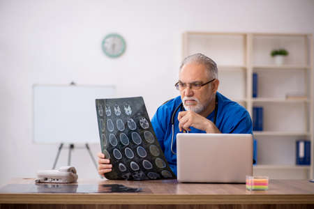 Old male doctor radiologist working in the clinicの写真素材