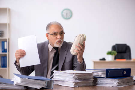 Old male employee in remuneration conceptの写真素材