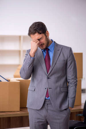 Young male employee in office relocation conceptの写真素材