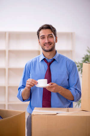Young male employee in office relocation conceptの写真素材