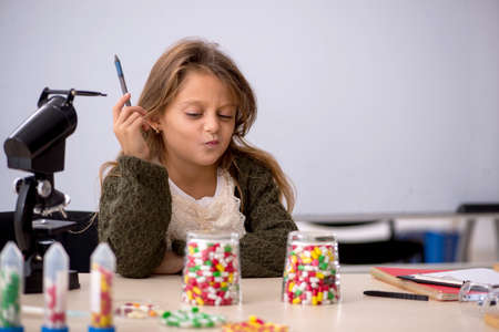 Young little girl chemist in drugs synthesis concept