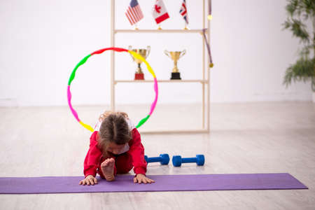 Young little girl doing sport exercises at homeの写真素材