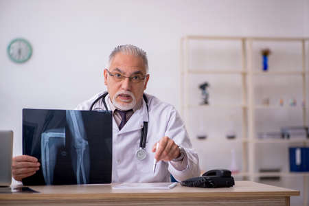 Old male doctor radiologist working at the hospitalの写真素材