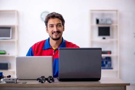 Young male repairman repairing computer