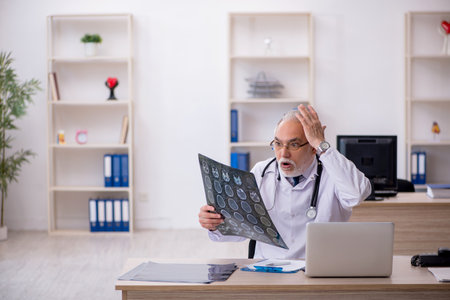 Old male doctor radiologist working in the clinic