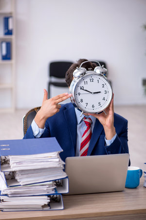 Young male employee in time management conceptの写真素材
