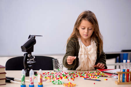 Young little girl chemist in drugs synthesis conceptの写真素材