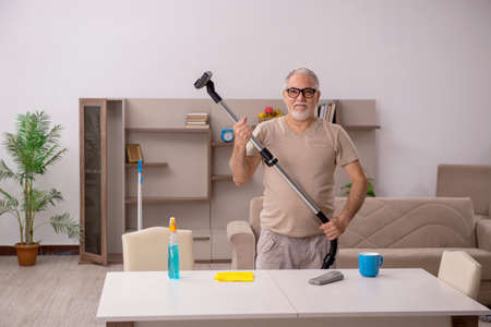 Old man doing housework at homeの写真素材