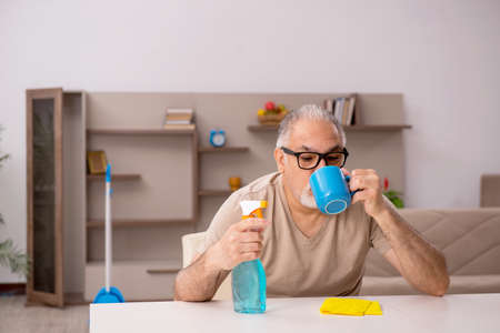 Old man doing housework at homeの写真素材