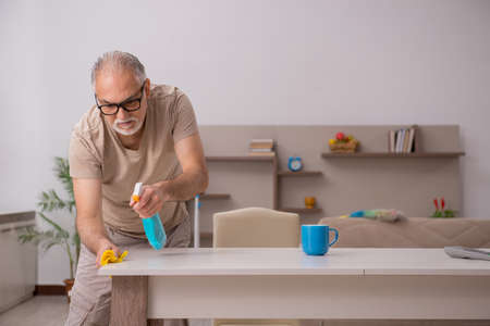 Old man doing housework at home