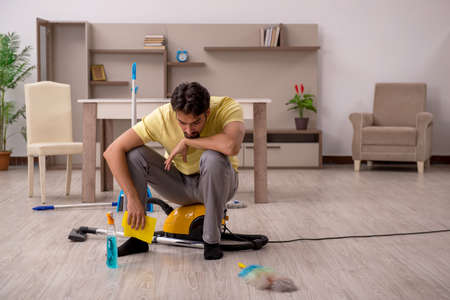 Young man doing housework at homeの写真素材