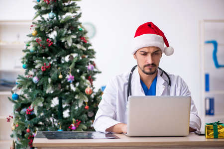Young male doctor celebrating Christmas at the hospitalの写真素材