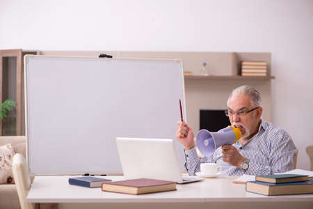 Old male employee working from home during pandemic