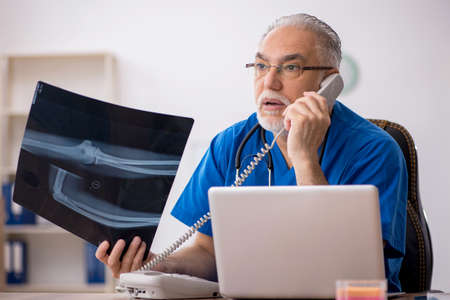 Old male doctor radiologist working in the clinic