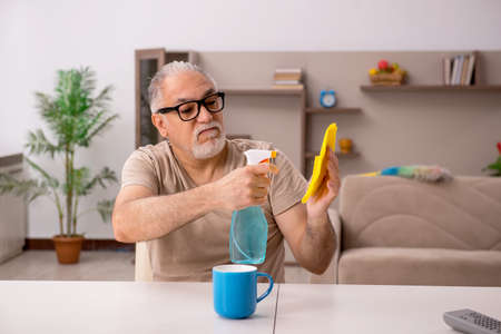 Old man doing housework at home