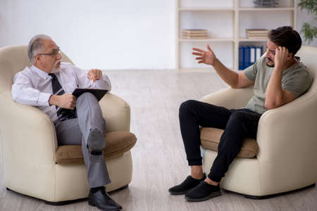 Young man visiting old psychologistの写真素材