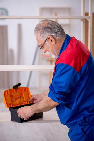 Old male carpenter working indoorsの写真素材